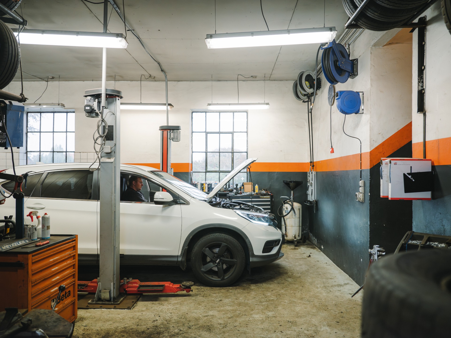 Happy black mechanic working on engine diagnostic at car service